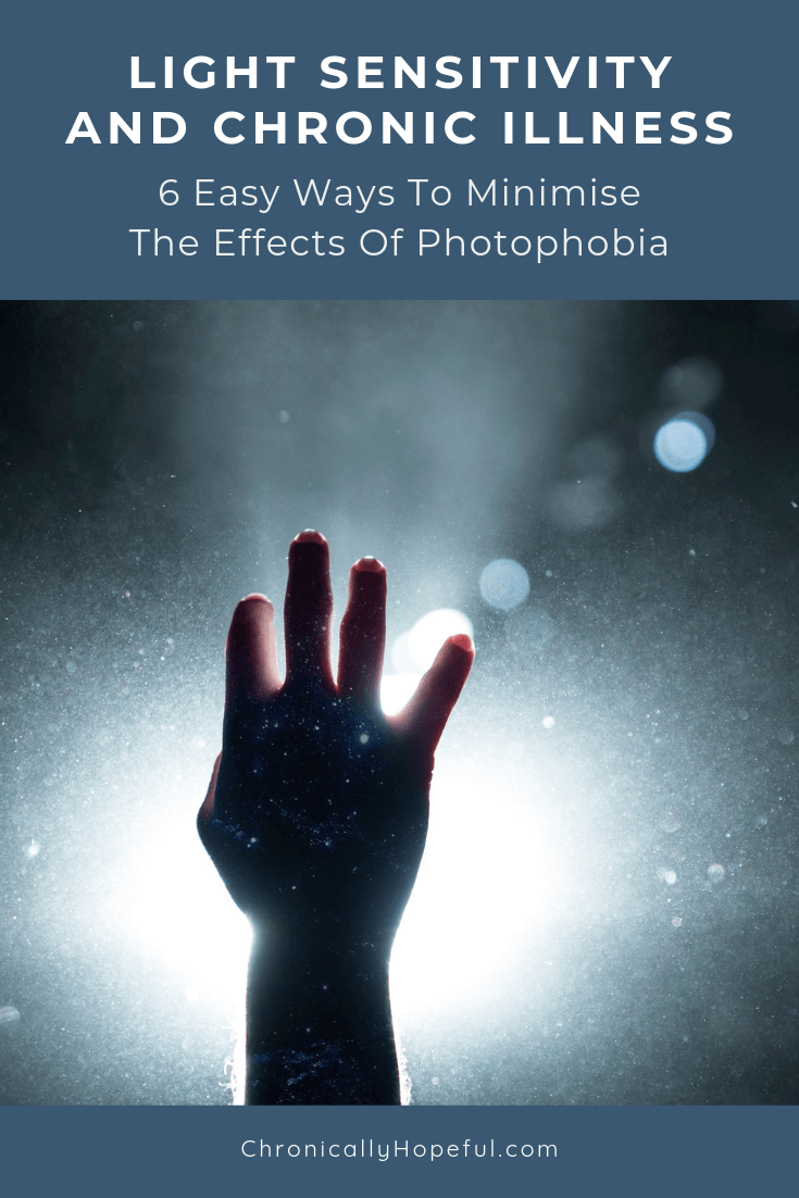 In a dark room a hand is held up to block out hte light that is coming in. Title reads, Light Sensitivity and chronic illness, 6 ways to minimise the effects of photophobia