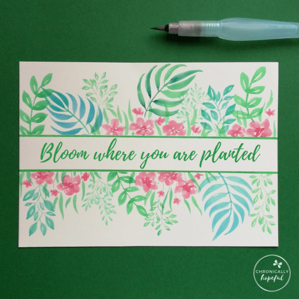 Leaves and flowers painted in watercolour on white card framing the quote bloom where you are planted, by Chronically Hopeful Char